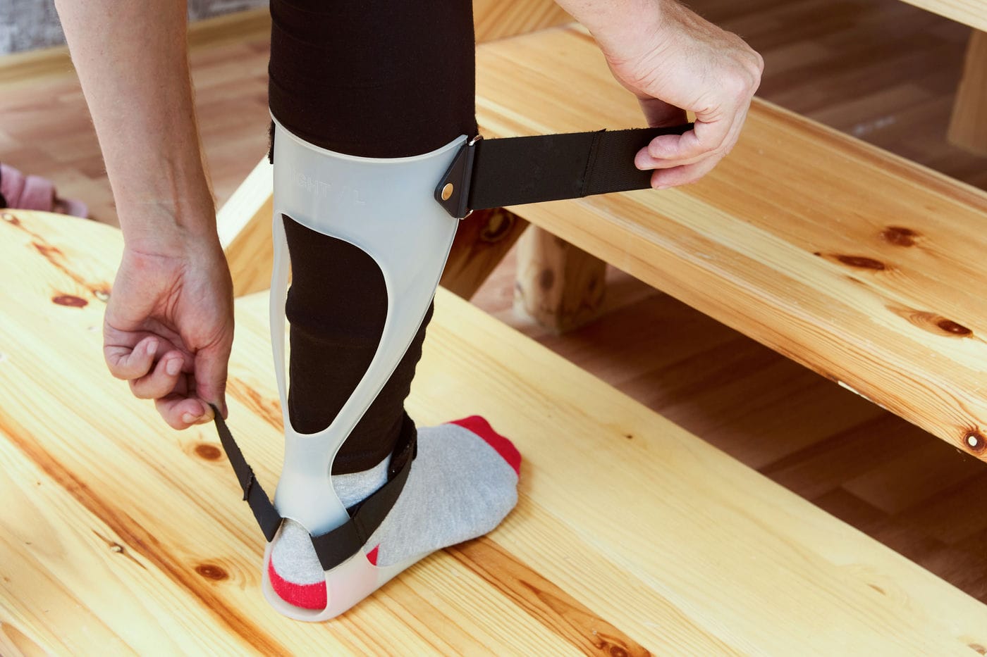 woman adjusting her ankle foot orthotic