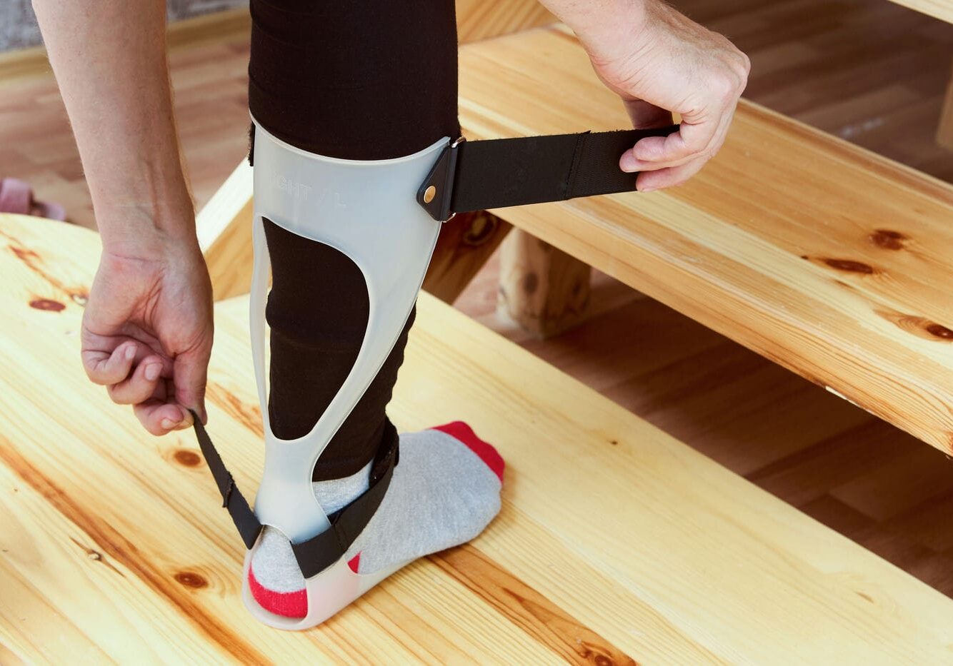 woman adjusting her ankle foot orthotic